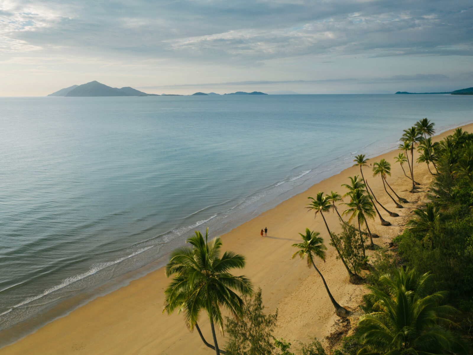 Aerial view of couple walking along the beach – Credit Tourism and Events Queensland